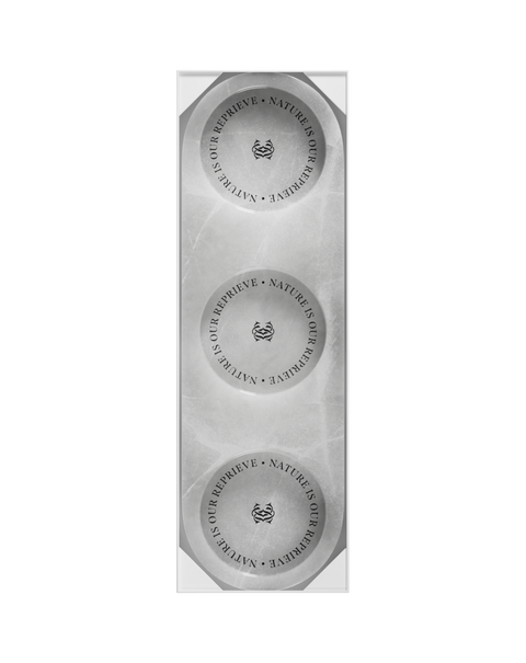 A circular white onyx triple tray with a product label in the center.