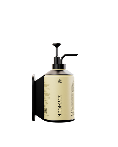 A wall bracket designed for mounting a 500ml Commune bottle
